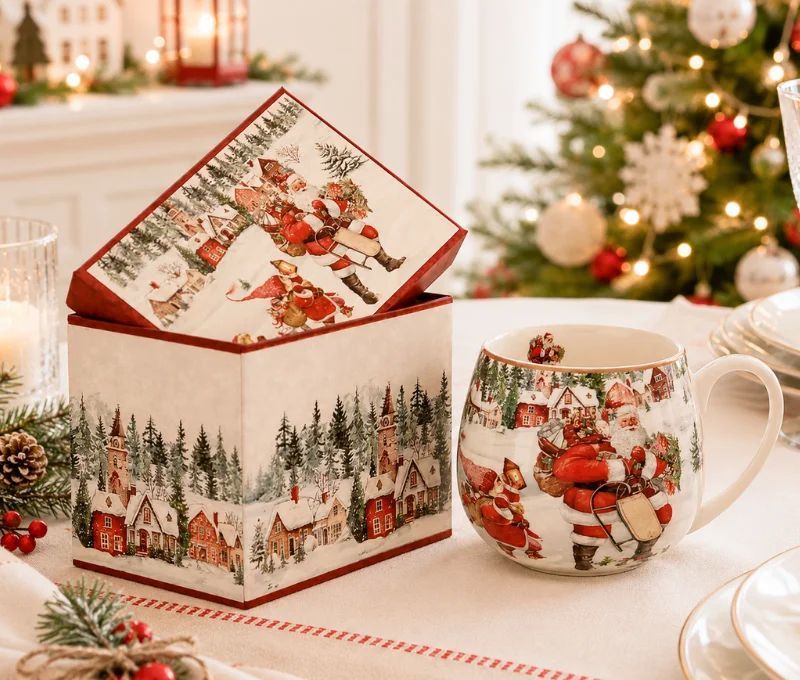 Mug pansu porcelaine crème illustration Père Noël village enneigé maisons rouges sapins et boîte cadeau carrée assortie