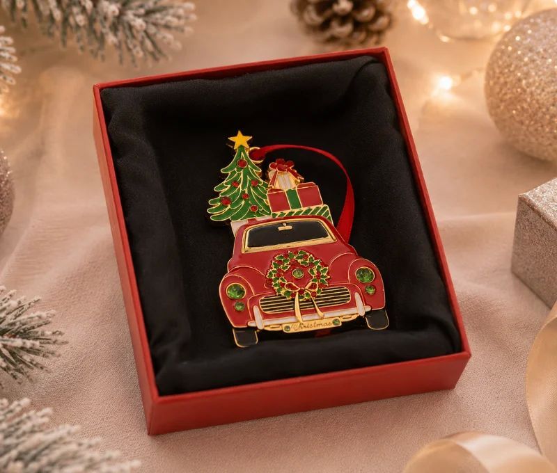 Suspension de Noël voiture rouge métal doré émaillé, sapin vert étoilé et cadeaux sur le toit, dans sa boîte cadeau