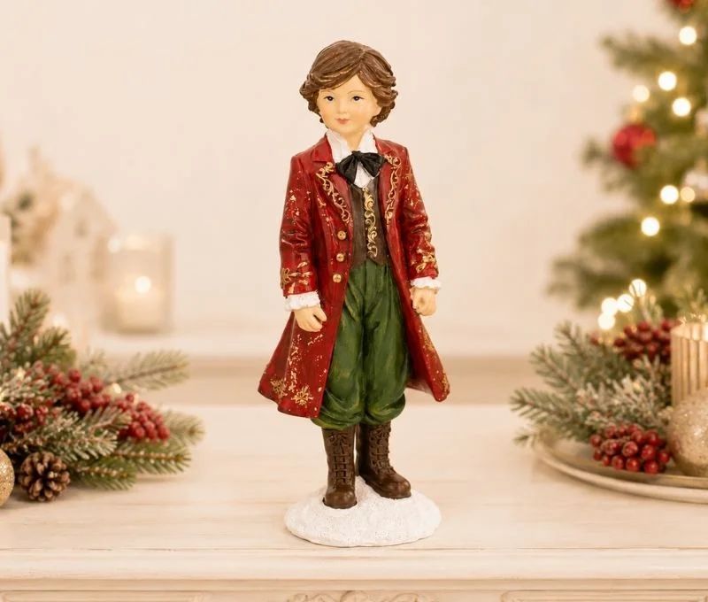 Figurine enfant garçon Noël poly manteau rouge doré veste verte pantalon vert nœud papillon noir bottes marron socle neige H17cm