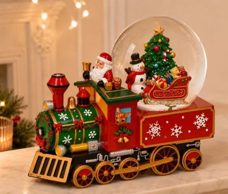 Boîte à musique boule à neige locomotive rouge verte Père Noël bonhomme de neige sapin traîneau roues dorées L25xP14xH21cm