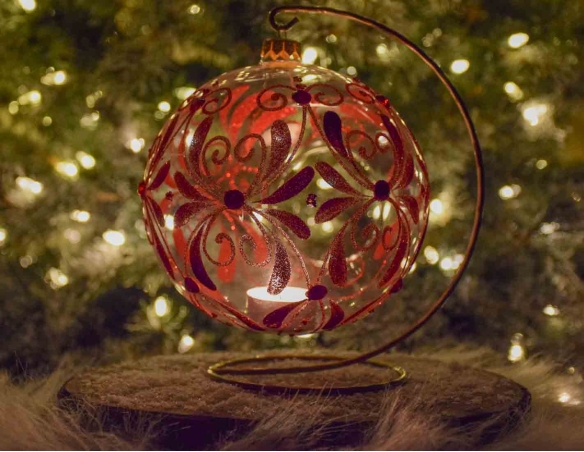Grande boule de Noël bougeoir en verre soufflé et décorée à la main avec un décor floral rouge et recouvert de paillettes.