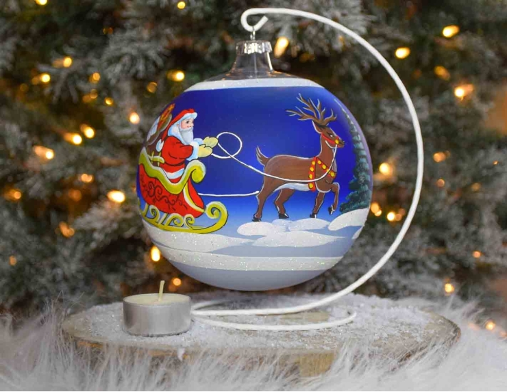 Grande boule de Noël bleu pour bougie, décor Père Noël sur son traineau tiré par des rennes. Diamètre 15cm.