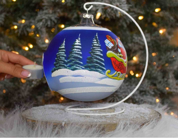 Grande boule de Noël bleu pour bougie, décor Père Noël sur son traineau tiré par des rennes. Diamètre 15cm.