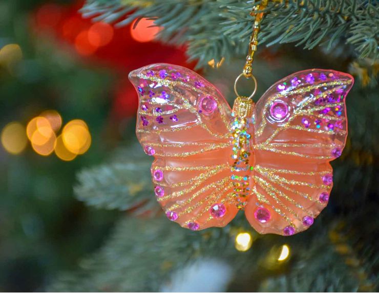 Boule de Noël papillon rose et orange en verre soufflé, strass et paillettes roses. Hauteur de 6cm, made in Europe.
