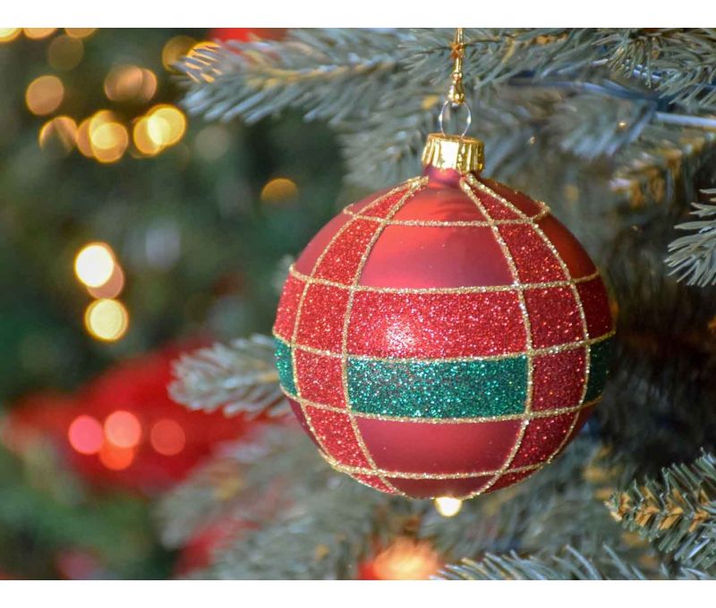 Boule de Noël rouge mat en verre, décor tartan en paillettes rouges et vertes, lignes dorées peintes à la main.