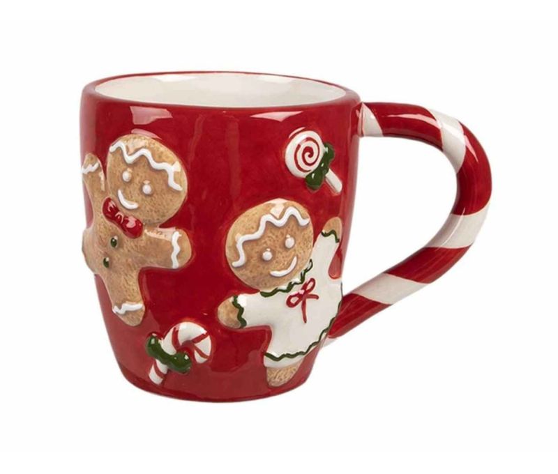 Tasse de Noël rouge avec des bonhommes en pain d'épices et des bonbons.