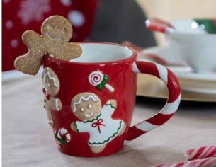 Tasse de Noël rouge avec des bonhommes en pain d'épices et des bonbons.