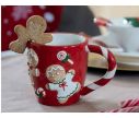 See slide Tasse de Noël rouge avec des bonhommes en pain d'épices et des bonbons.