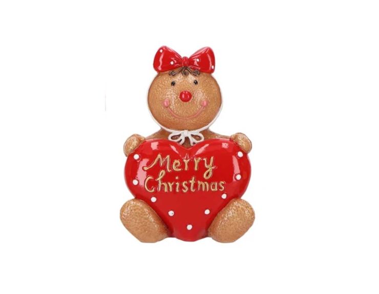 Figurine pain d’épices assis tenant un cœur rouge avec l’inscription “Merry Christmas”. Figurine en résine H14cm.
