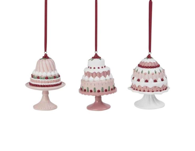 Set de 3 suspensions en forme de gâteaux rose en résine. Hauteur : 12 cm. Ruban rouge pour accroche.