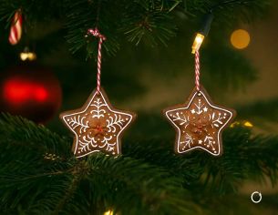 Set de 2 suspensions étoiles façon pain d’épices avec motifs blancs. Hauteur : 7 cm