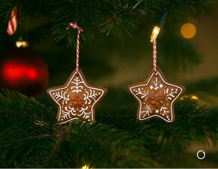 Set de 2 suspensions étoiles façon pain d’épices avec motifs blancs. Hauteur : 7 cm