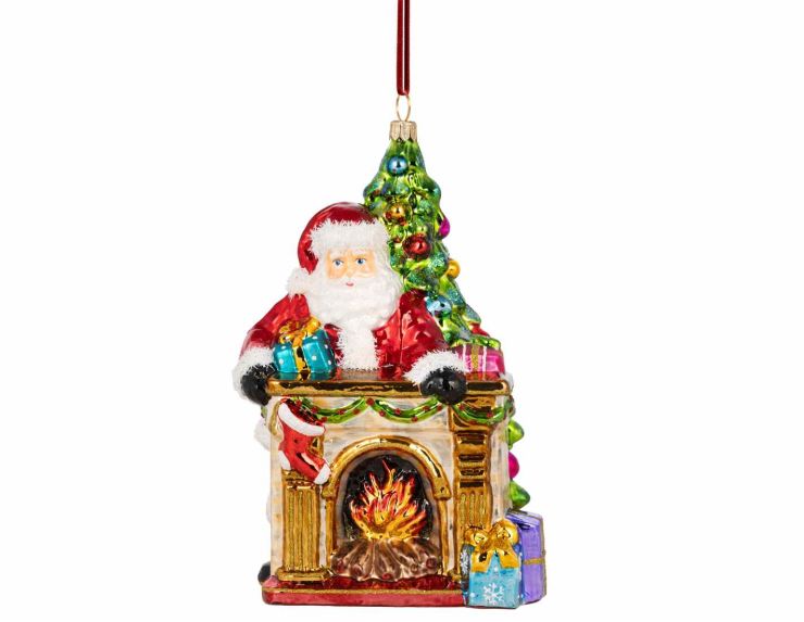Suspension de Noël en verre soufflé avec Père Noël, cheminée illuminée et sapin décoré. Peinte à la main. Hauteur : 18 cm.